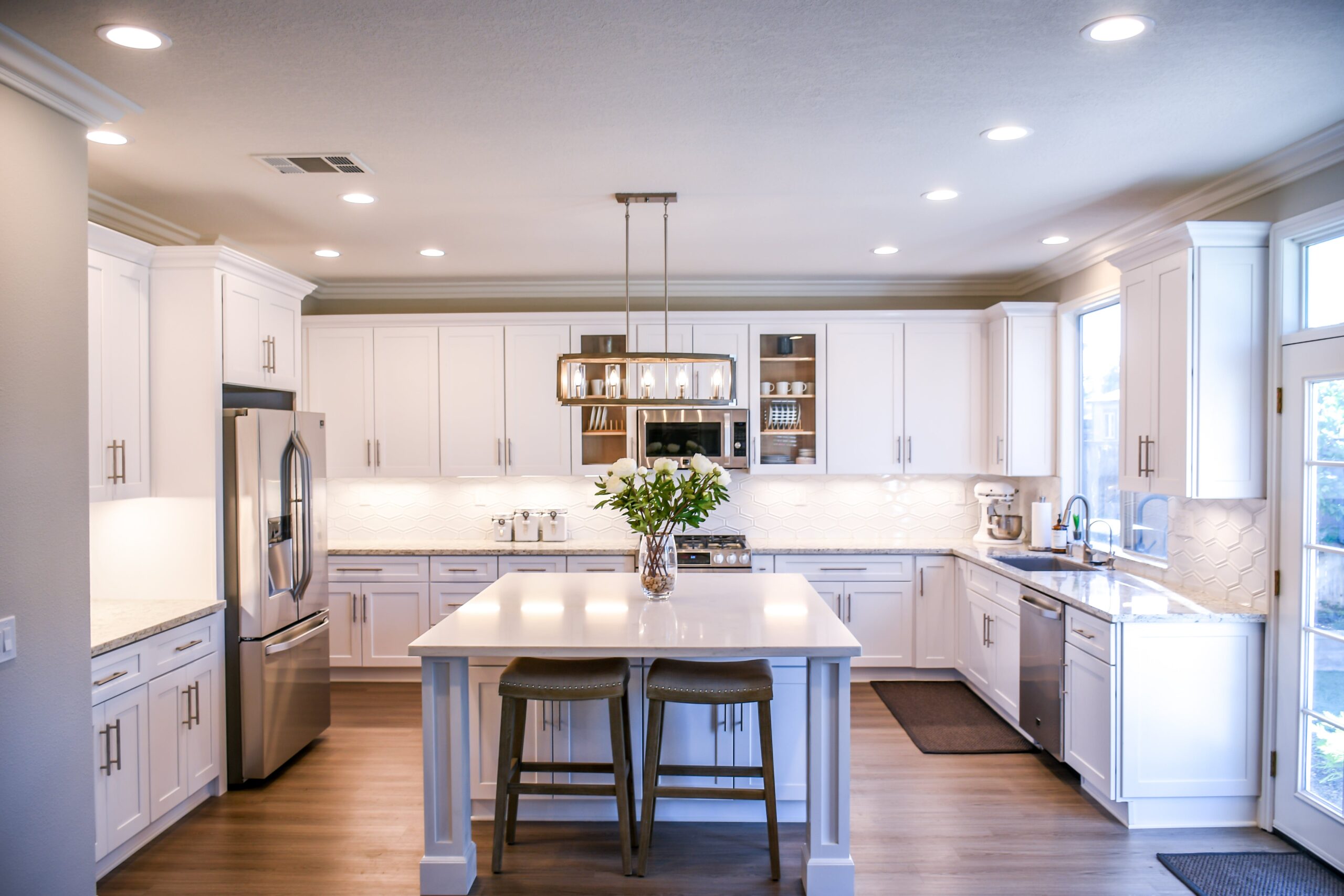 a kitchen with white cabinets, stainless steel appliances, and glass splashbacks for easy cleaning.